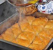 Hete siroop over de lauwe baklava gieten