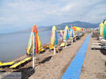 Parasols en ligbedden aan strand van Skala Kallonis - Foto van De Griekse Gids