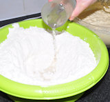 Neem nu  een andere kom en doe daar het meel in